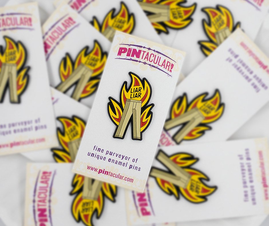 A pile of Liar Liar pins on printed Pintacular backing cards