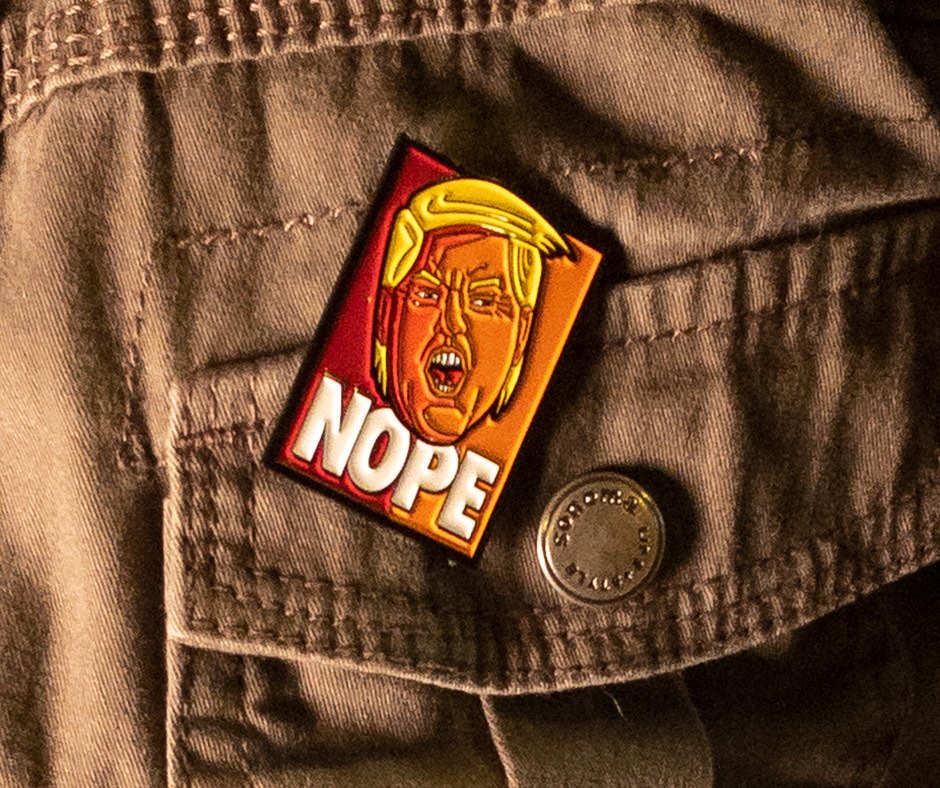 NOPE pin pinned to the chest pocket of an army jacket